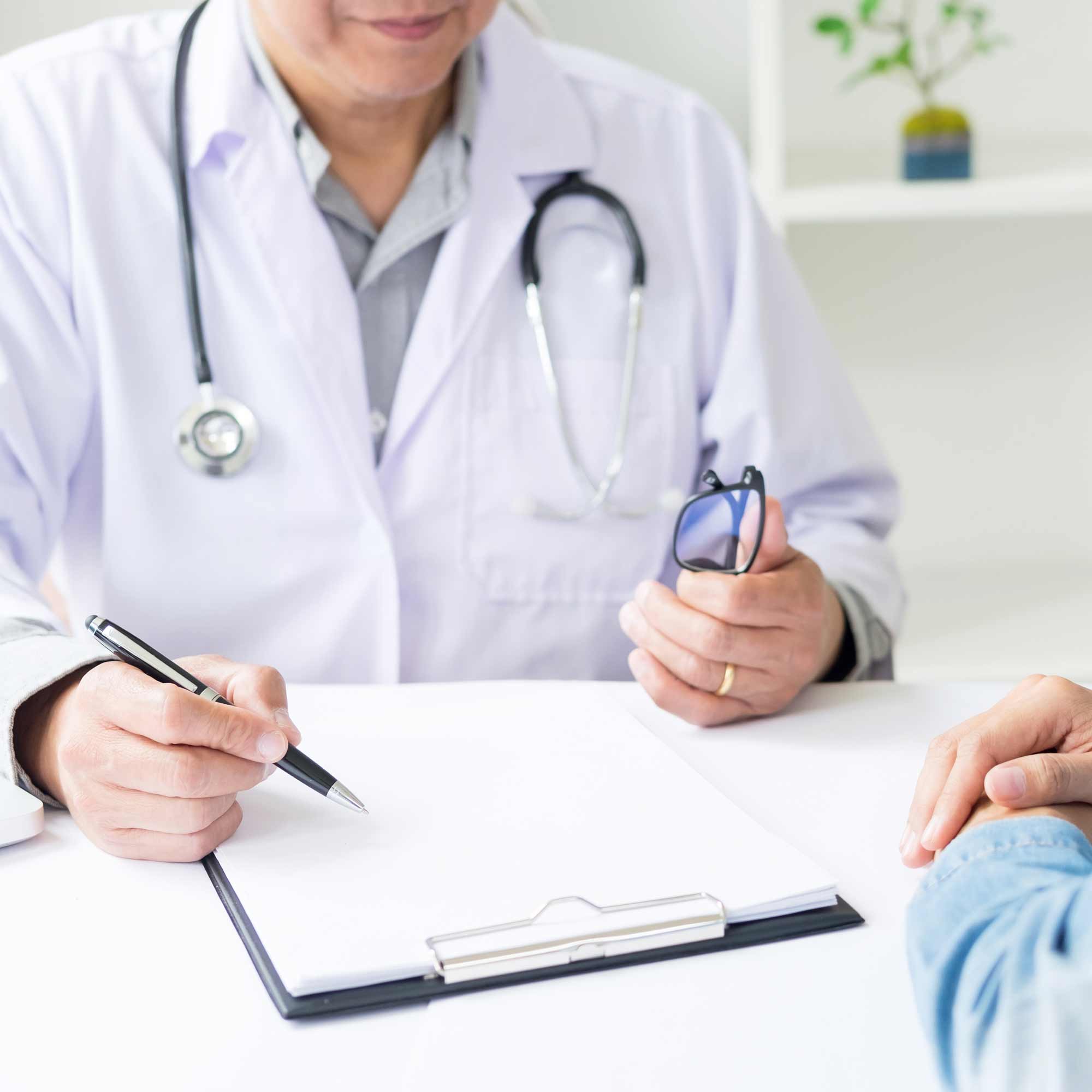 Doctor discussing care with a patient and writing on a clipboard