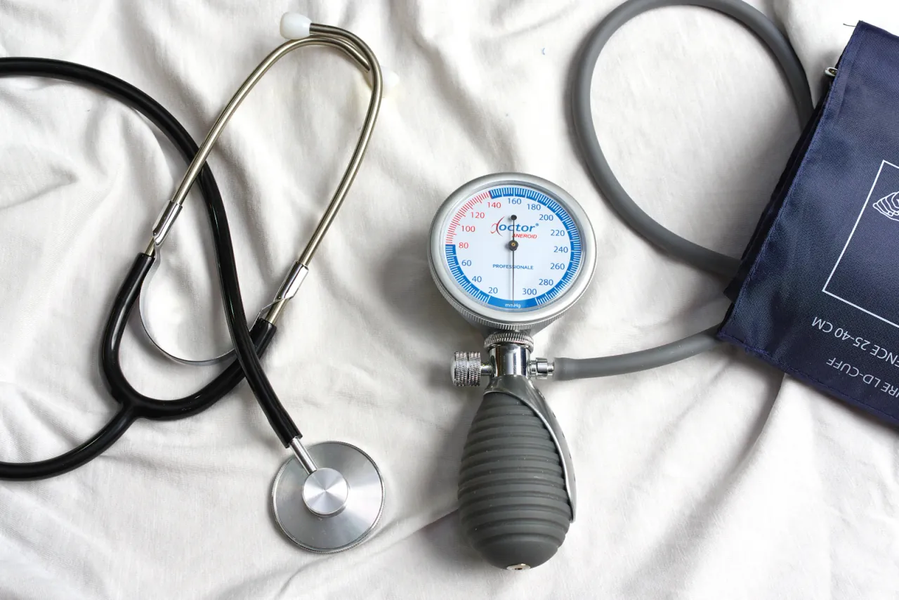 A stethoscope and manual blood pressure monitor on a white surface