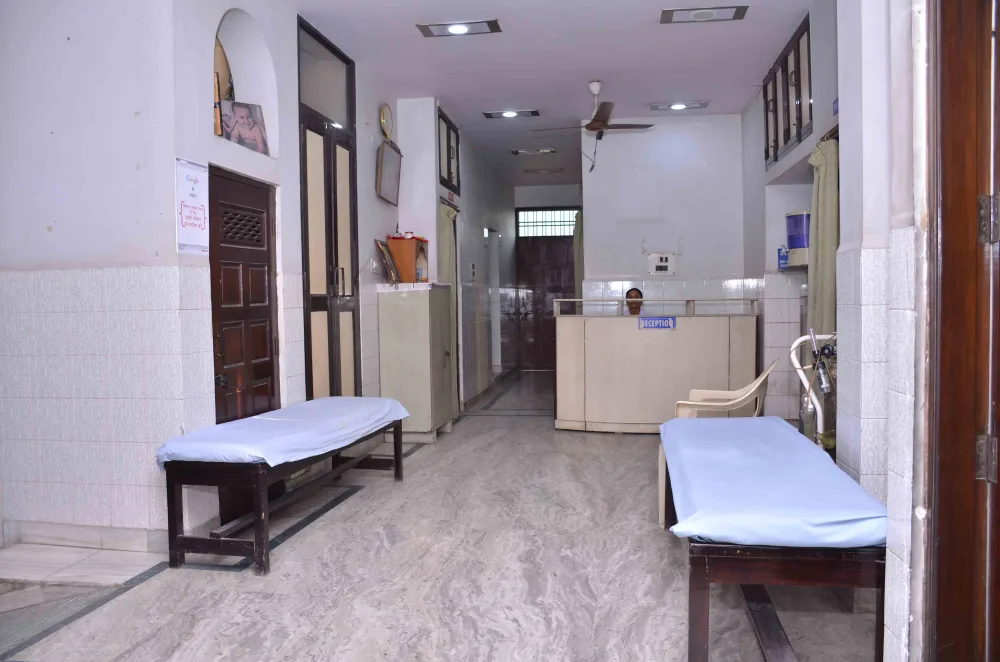 Hospital reception desk at the end of a corridor with waiting benches